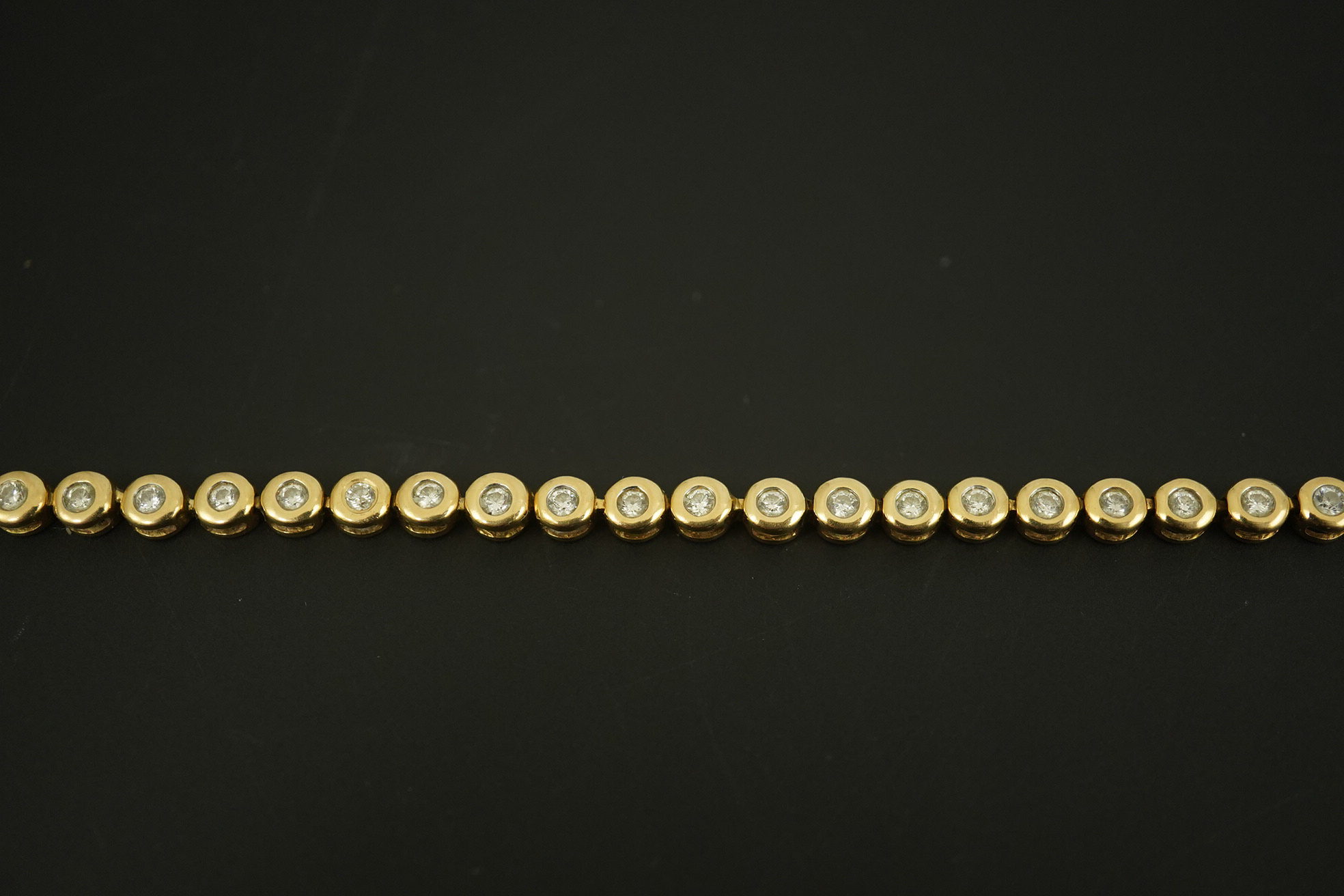 A modern gold and forty five stone round cut diamond set tennis bracelet